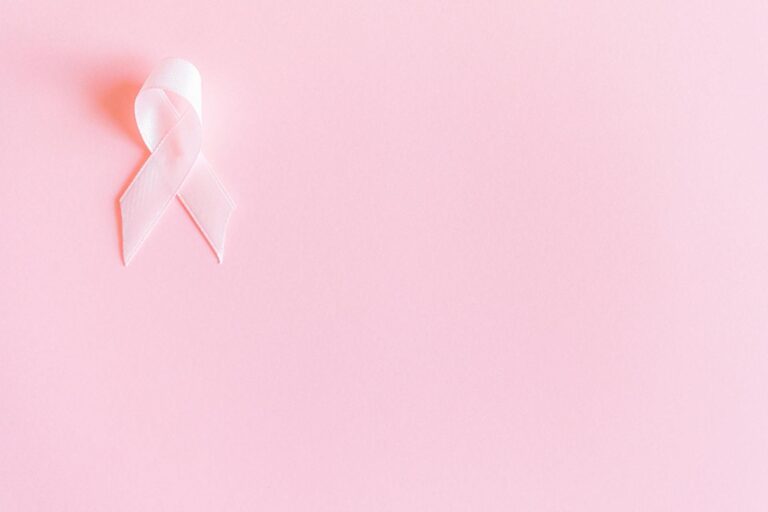 Triple-negativer Brustkrebs: Symptome und neue Therapien A pink ribbon on a soft pink background symbolizing breast cancer awareness and solidarity.