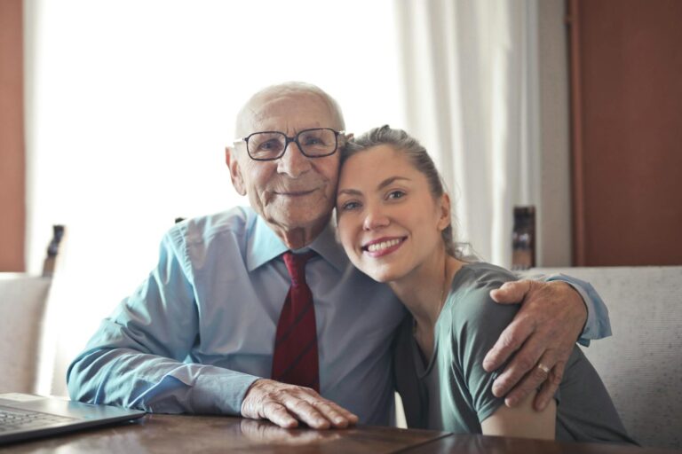 Alzheimer A joyful elderly man and young woman sharing an affectionate embrace indoors.