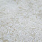 A detailed close-up shot of uncooked white rice grains, emphasizing texture and natural quality.