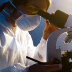 A female scientist uses a microscope in a laboratory, focusing intently on her research.