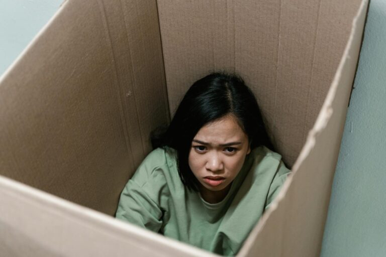 Persistente wahnhafte Störung A woman inside a cardboard box symbolizes feelings of anxiety and claustrophobia.